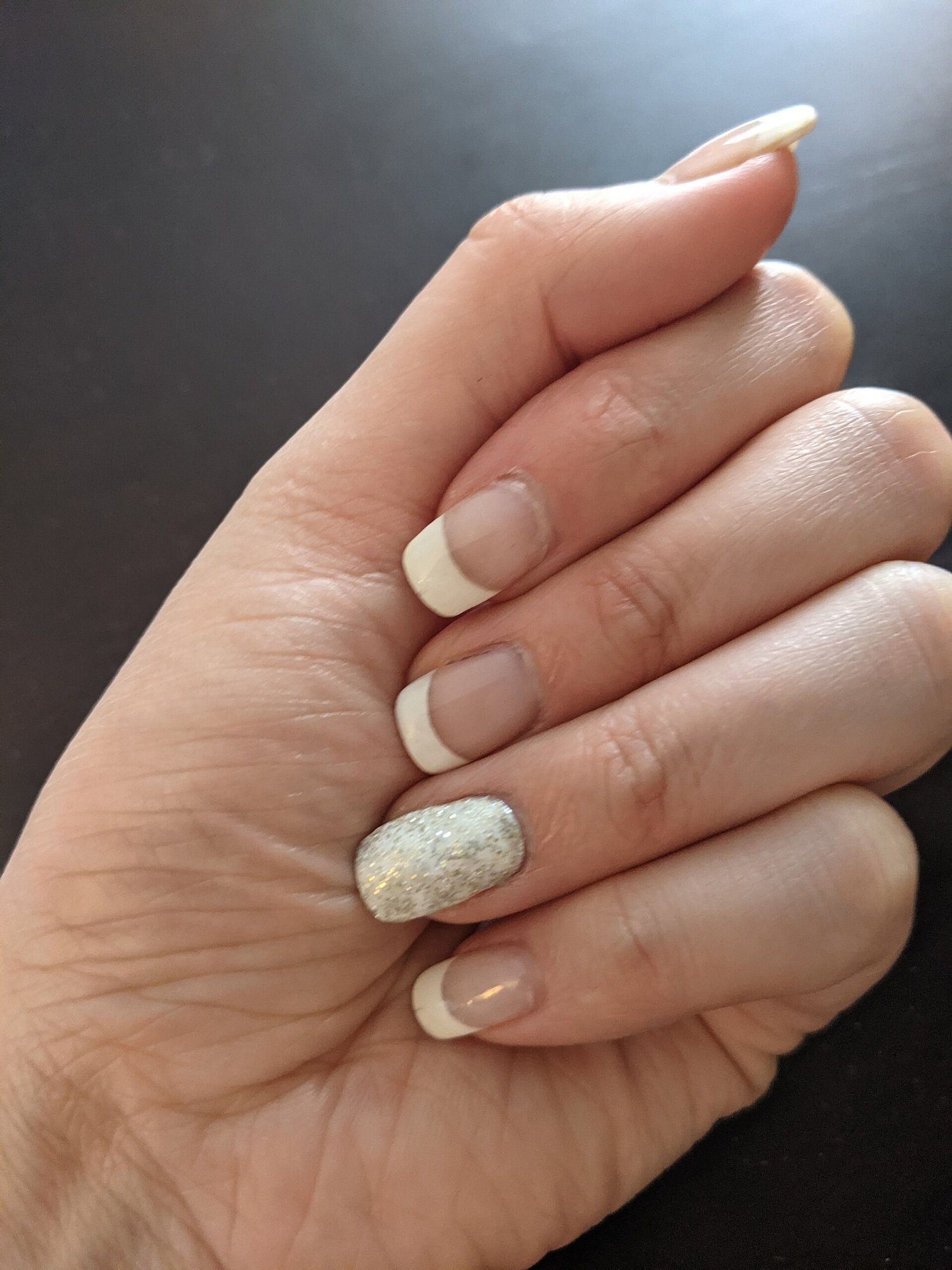 Mão com unhas em francesinha e detalhe brilhante