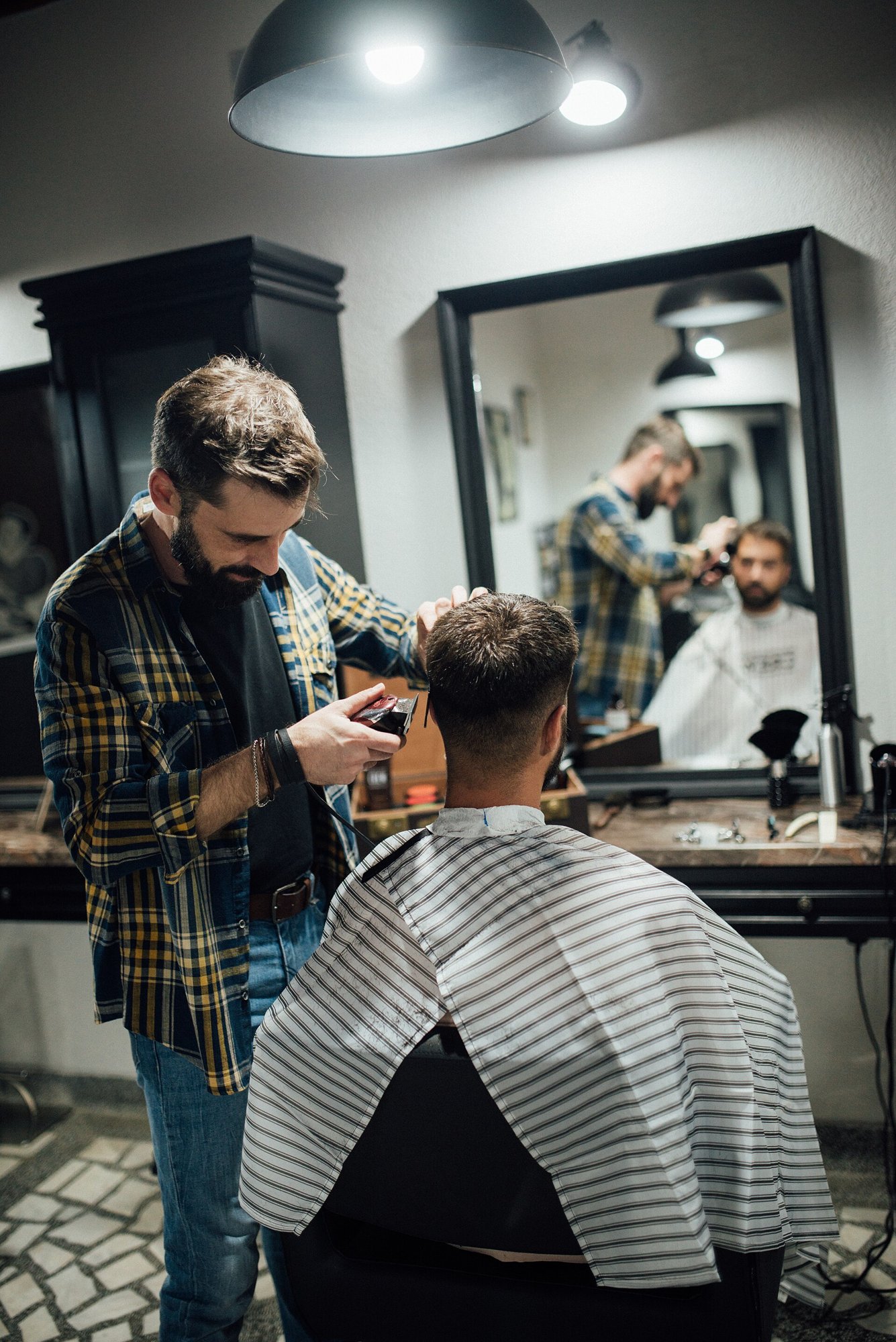Barbeiro cortando cabelo de cliente em barbearia